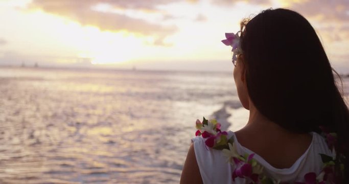 Hawaii Beach Travel Vacation - Woman Looking at Sunset on Waikiki Beach, Hawaii, wearing Lei flower garland on Hawaiian beach. Girl enjoying sunset on Oahu, Hawaii, USA