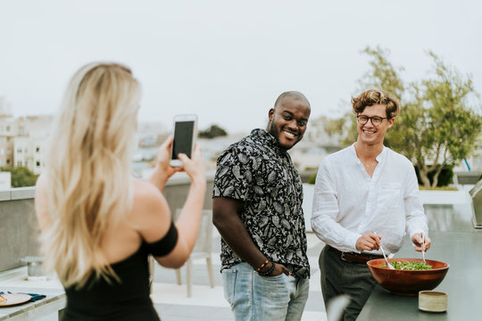 Diverse friends getting their picture taken at a rooftop party