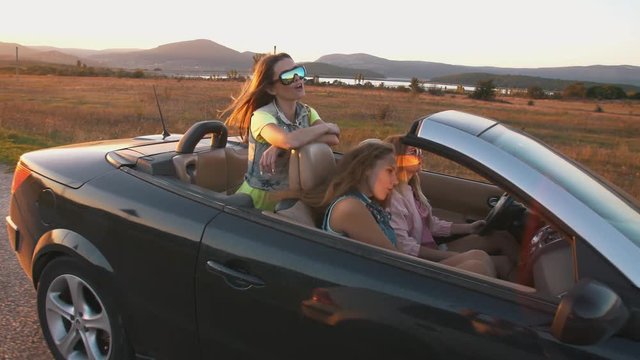 Young women having a fun in a convertible car