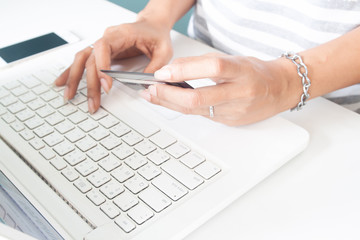 Woman's hands using laptop and credit card. Online payment, internet banking