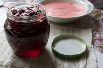 strawberry jam in a jar and oatmeal on an old table