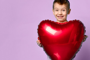 Little boy love hold big red heart balloon to celebrate valentines day on purple 