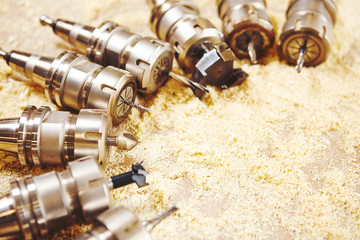 Woodworking bits for router machine on sawdust.