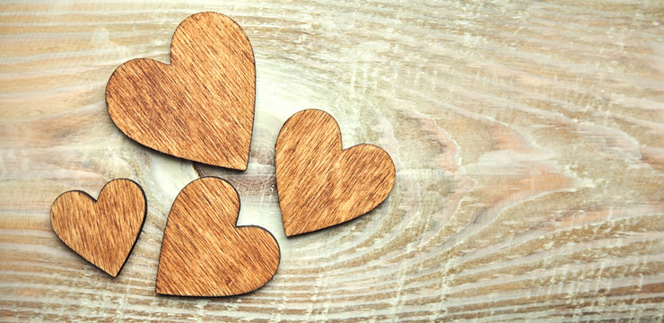 Four wooden hearts on the wooden table