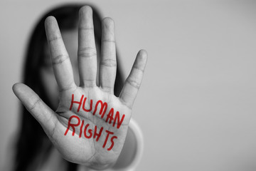 human rights concept. woman raised her hand for dissuade, hand write the word human rights in red...