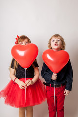 Fototapeta na wymiar Adorable little kids with heart shaped balloon smiling at camera isolated on white
