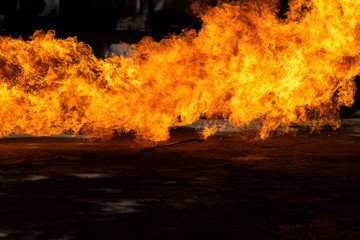Flames caused by the explosion of the oil isolated on black background. Demonstration of water on oil fire.
