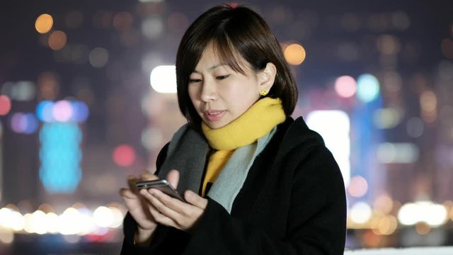Woman Use Of Smart Phone At Night in Hong Kong