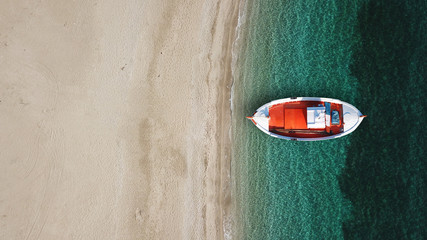 Aerial drone top view photo of iconic beach of Psarou with emerald clear sandy organised beach with sunbeds and umbrellas and traditional fishing boat, Mykonos island, Cyclades, Greece - obrazy, fototapety, plakaty