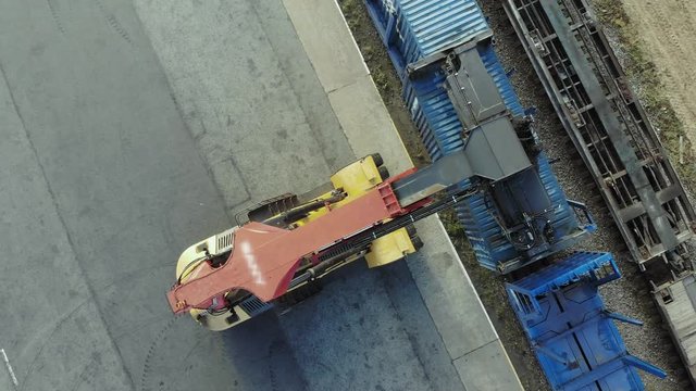 Containers are being lifted on to a block train by means of a transtainer. Aerial, top view.