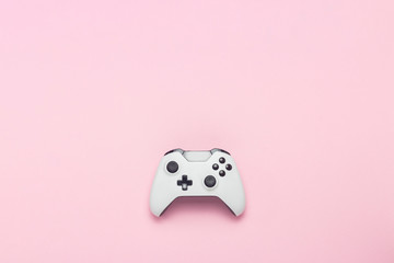 White gamepad on a pink background. Concept game on the console, computer games. Flat lay, top view.