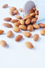 Almond nut in white on white wooden table background