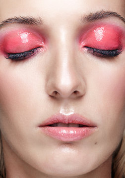 Closeup macro shot of female face and pink smoky eyes makeup