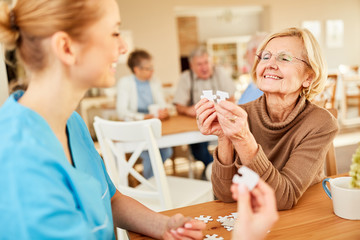 Senior Frau mit Demenz beim Puzzle spielen