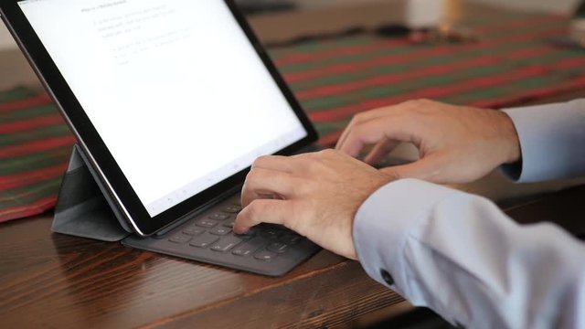 Close Up Business Man's Hands As He Types On IPad.