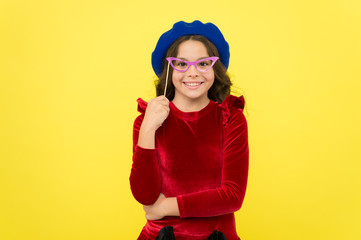 Lets have fun. Party accessories concept. She ready start party. Child with long hair and fashionable hat. Birthday party photo booth props. Kid girl cheerful posing with eyeglasses party attribute