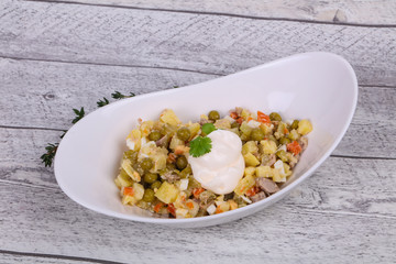 Traditional Russian salad with chicken in the white bowl