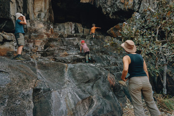 Frau mit Kindern sucht Felszeichnungen auf einem Hügel in der Nähe von Savuti, Chobe National...
