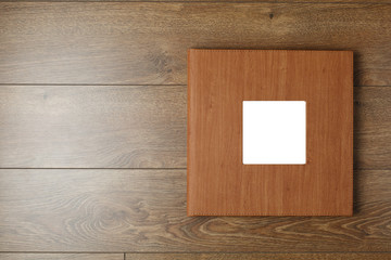 photo book in a leather cover with a photo print. brown photo album  on a wooden background with copy space for text