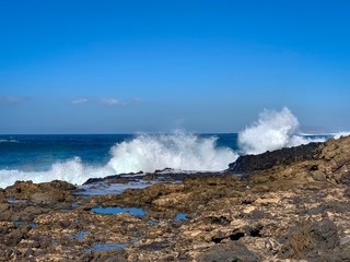 Fototapeta na wymiar Ocean waves crashing of coast rocks on Fuerteventura island