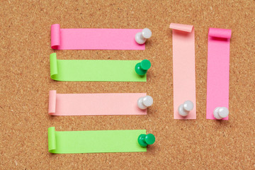 colorful sticky notes with pushpins and blank space,  on cork background