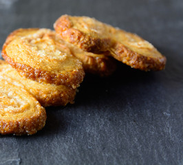 Three palmier cookies on a black board