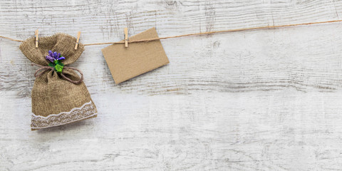 Small gift sack with heart note in wooden background