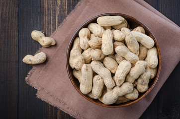 Peanuts in the peel on a dark background.