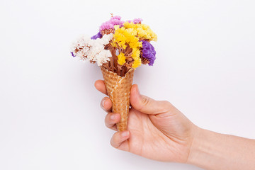 Woman is holding dry flowers in ice cream cone. Rustic still life.