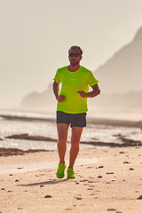 Man running / jogging on a tropical exotic beach.