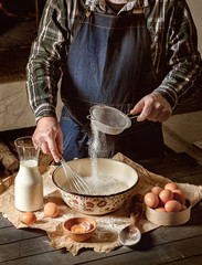 Man sifts flour and knead dough