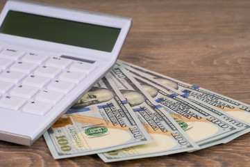 white calculator on 100 dollars banknotes