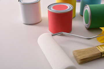 Colored paint pots and tools on white table elevated view