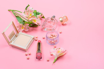 cosmetics and accessories on a pink background