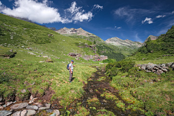 Fototapeta na wymiar A hiker walks along a path on the slopes of Monte Rosa in Piedmont, Italy.