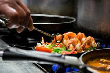 Man cooking shrimps and prawns on the stove