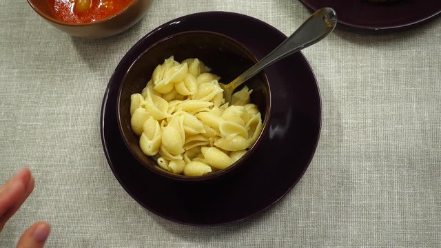 The process of eating pasta with lecho sauce.