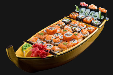 Sushi set in a wooden boat on a black background
