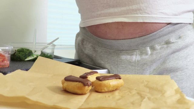 Man eating eclairs.Overweight concept