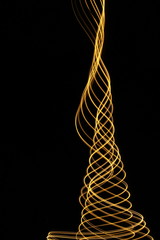 Light painting, long exposure photography, vibrant metallic yellow gold color and motion against a black background