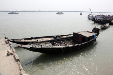 Wooden boat crosses the Ganges River in Gosaba, West Bengal, India