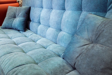 Close-up comfortable blue soft sofa with curly stitching. Modern design