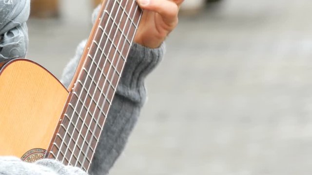 Nuremberg, Germany - December 1, 2018: Street guitar professional playing skillfully playing acoustic guitar in street. Guitarist hands playing a wooden guitar