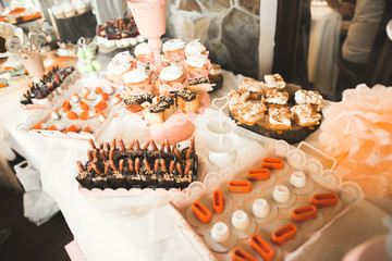 Delicious and tasty dessert table with cupcakes shots at reception closeup