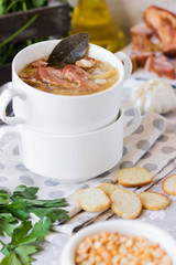 Thick pea soup with smoked meats in a white plate