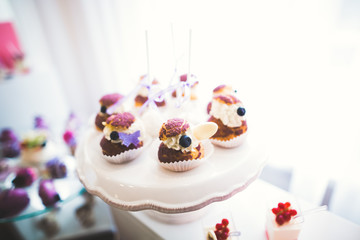 Delicious sweets on wedding candy buffet with desserts, cupcakes