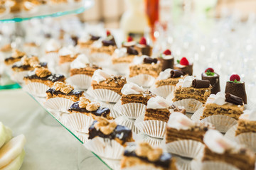 Delicious sweets on wedding candy buffet with desserts, cupcakes
