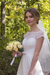 Beautiful bride in fashion wedding dress on natural background.Wedding day. A beautiful bride portrait in the forest.