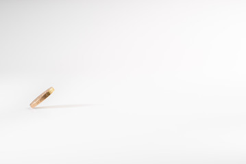 1 British pound coin falling on white background, isolated