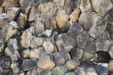 Textured basalt background hexagonal stone pillars in a section. natural volcanic formations